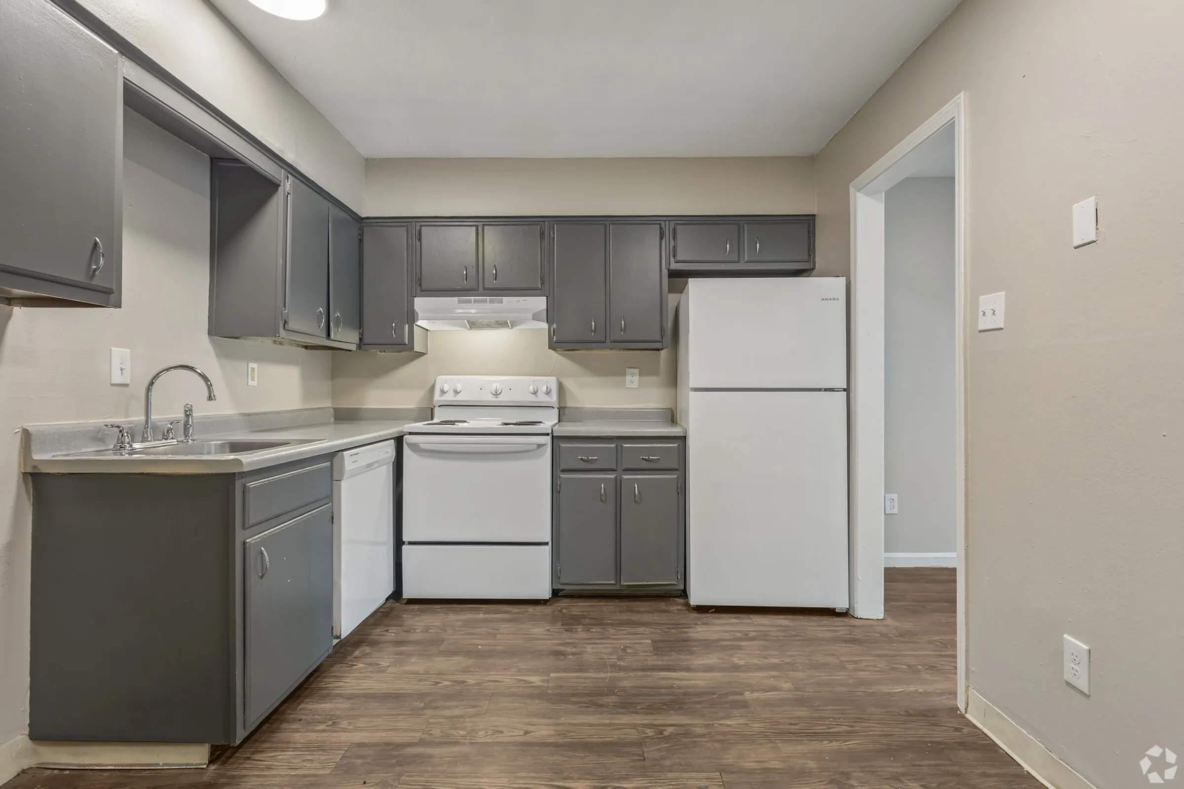 Kitchen with gray shaker cabinets and white appliances in a 2 bedroom townhome at Shadowbrook Townhomes in Memphis, TN