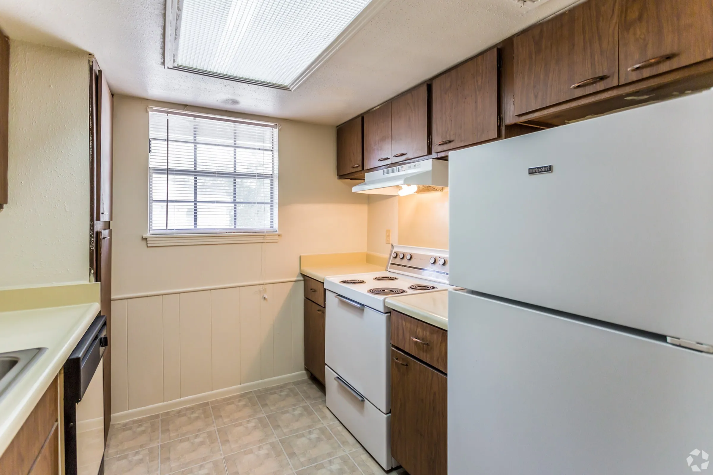 2 bedroom kitchen with skylight, wood cabinets, and white range at Windsor Place Apartments in Memphis, TN