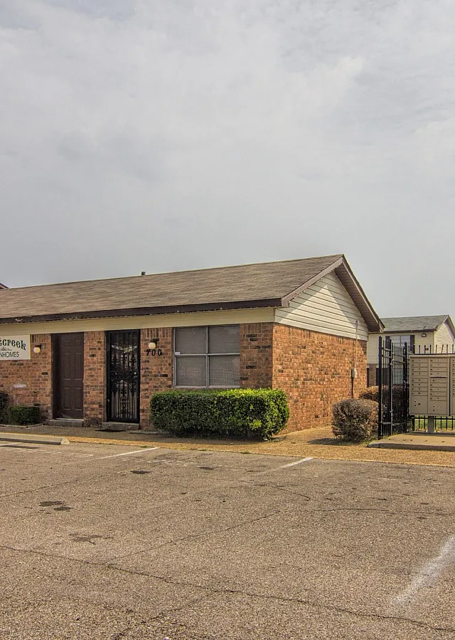 Brick building with open parking at Bent Creek Apartments in West Memphis, AR