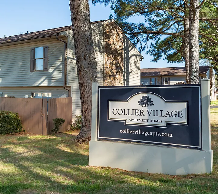 Entrance sign in front of townhomes at Collier Village Apartments in Collierville, TN