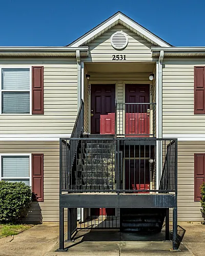 Two-story building with red shutters and stairs at Countryside Village in Memphis, TN