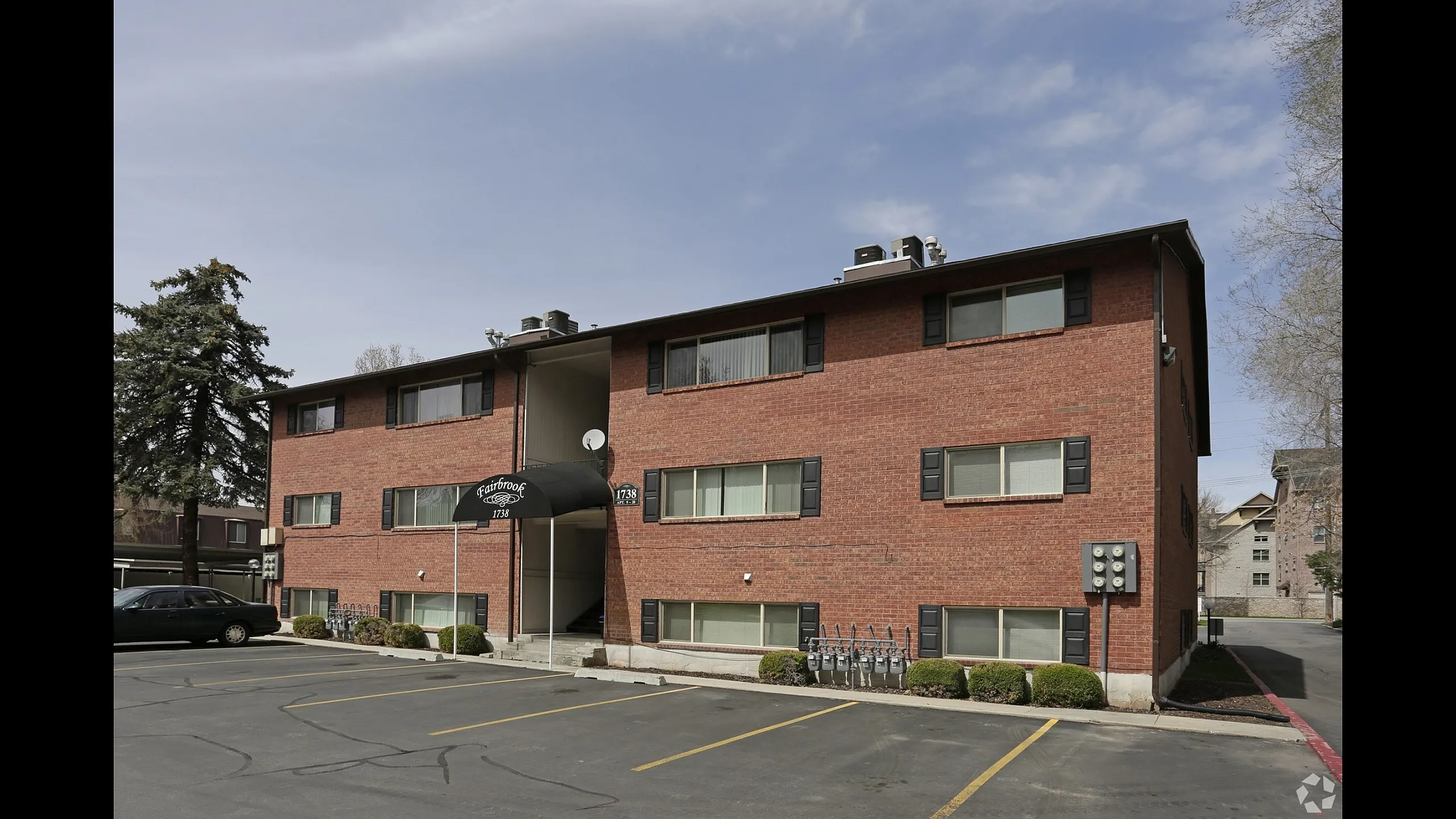 Brick apartment buildings overlooking the parking lot at Fairbrook in Salt Lake City, UT