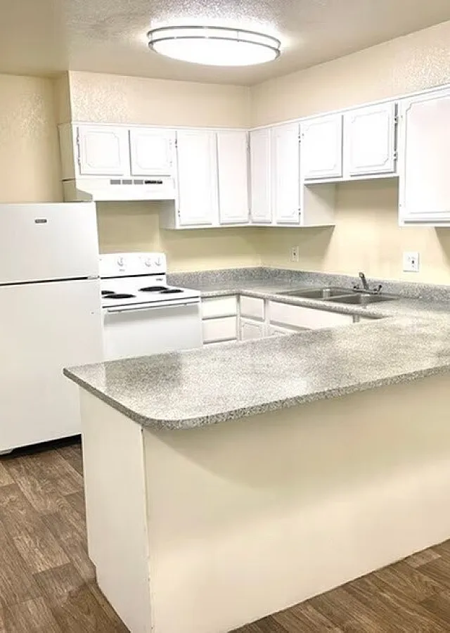 Updated kitchen with gray counters and white cabinets at Fairbrook in Salt Lake City, UT