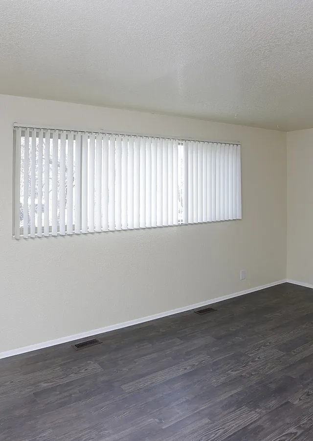 Living room with vertical blinds and wood-style floors at Fairbrook in Salt Lake City, UT