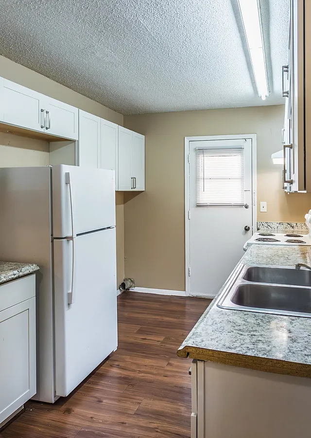 Kitchen with white cabinets and granite counters at Foxhaven Apartments in Southaven, MS