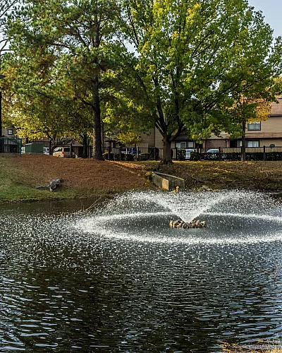 Pond with fountain beside apartment buildings at Hickory Forest in Memphis, TN