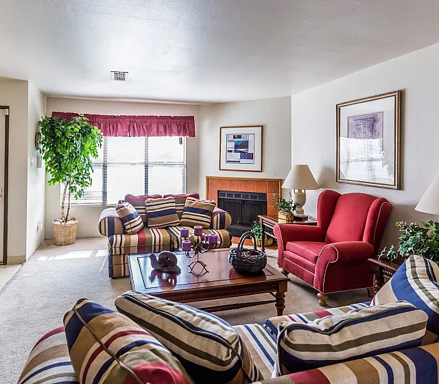 Furnished model living room with fireplace at Hickory Forest in Memphis, TN