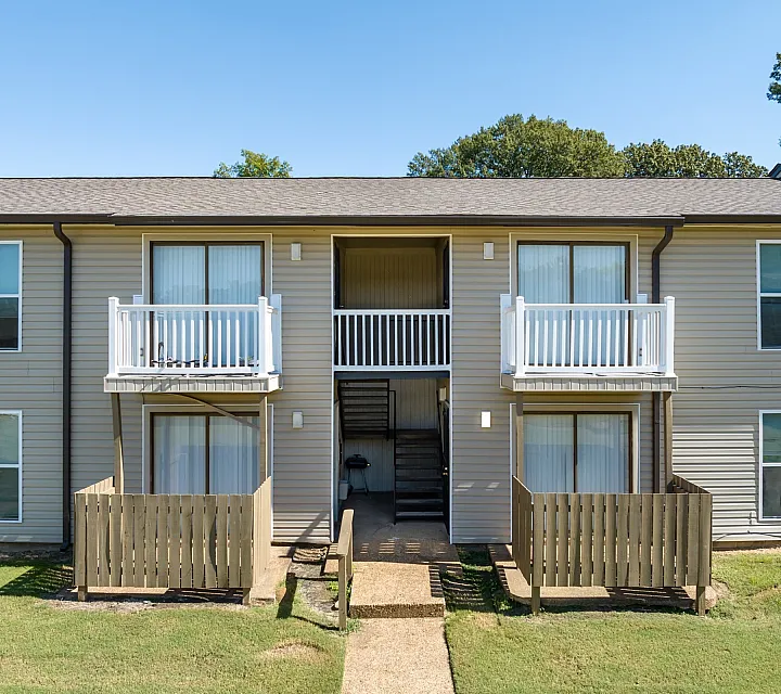 Front of a building with balconies and wood patio fences at Hunter Oaks Apartments in Memphis, TN
