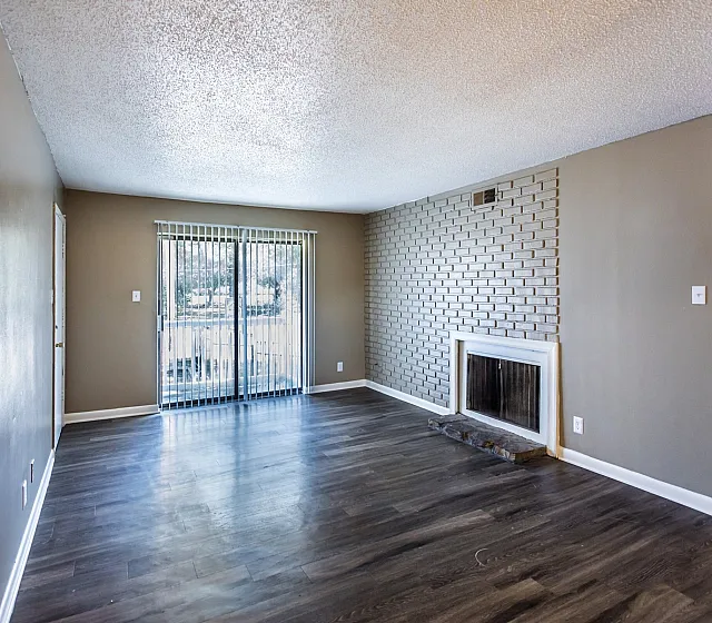 Living room with a white brick fireplace at Hunter Oaks Apartments in Memphis, TN