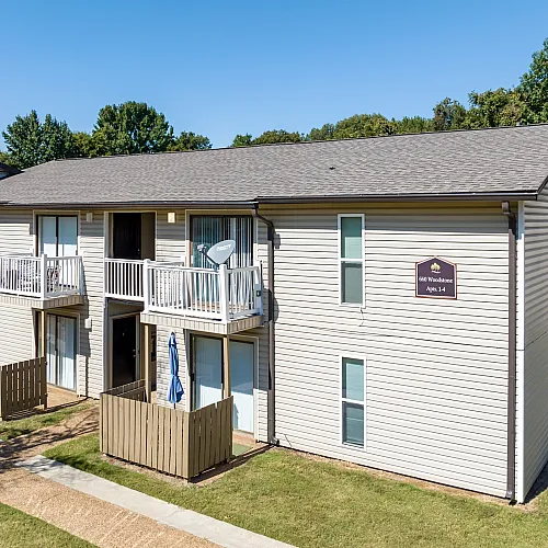 Two-story building with upper balconies on a sunny day at Hunter Oaks Apartments in Memphis, TN