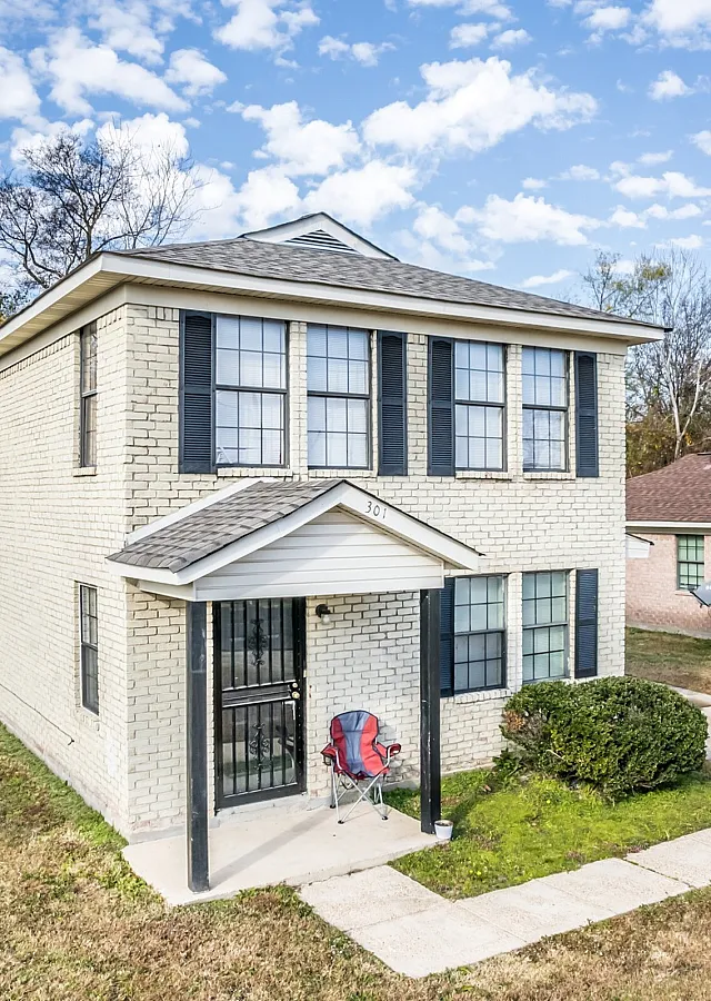 Two-story home with white siding and a porch at Jackson Heights Residential in West Memphis, AR