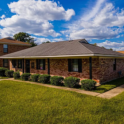 Brick ranch homes lining a green lawn at Jackson Heights Residential in West Memphis, AR