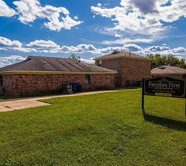 Community sign on a lawn beside brick homes at Jackson Heights Residential in West Memphis, AR