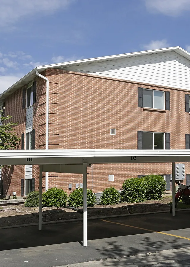 Covered resident parking next to a brick building at Linden Colonial in Holladay, UT