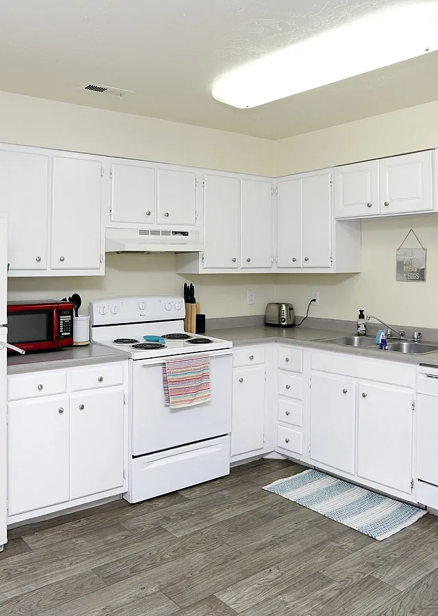 Bright white kitchen with white appliances at Linden Colonial in Holladay, UT