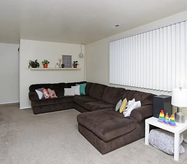 Living room with a large brown sectional sofa at Linden Colonial in Holladay, UT
