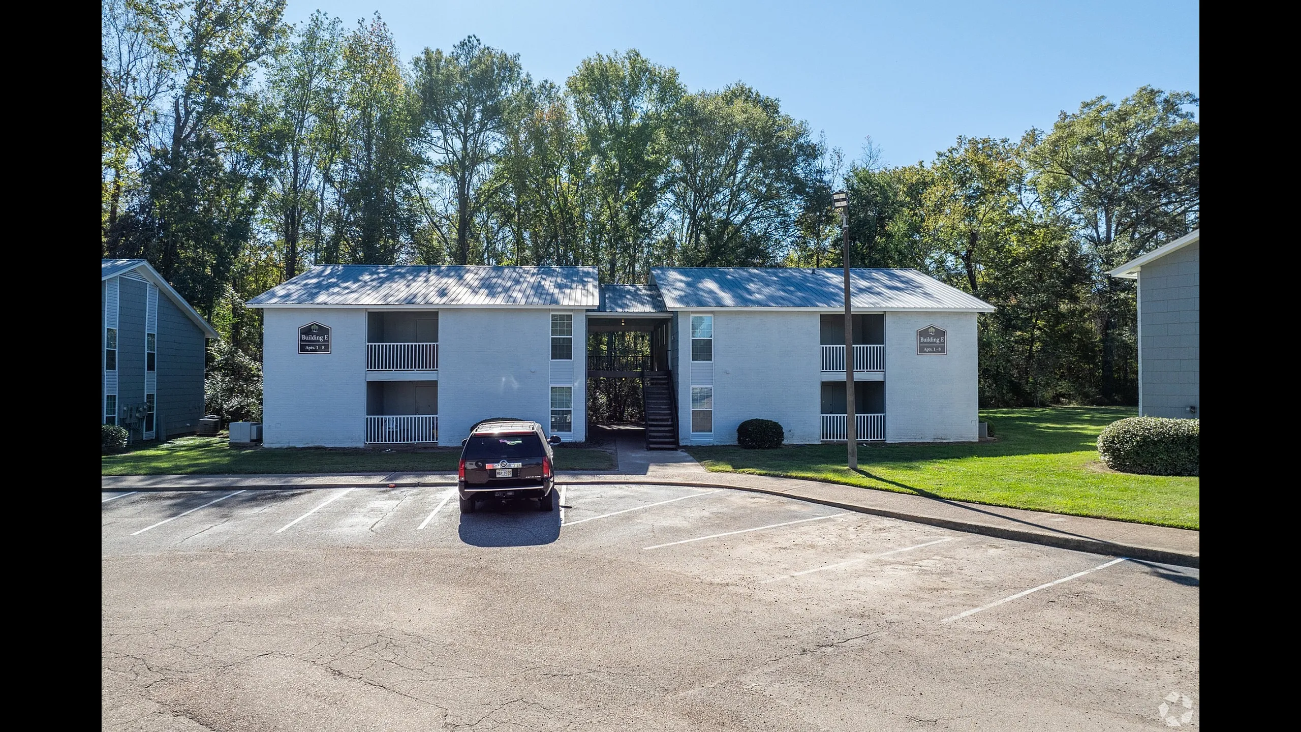 Two-story apartment building and resident parking at Meadow Creek Apartments in Jackson, MS