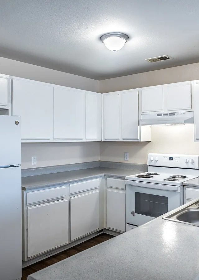 Bright kitchen with white cabinets in a 3-bedroom at Meadows West Memphis Apartments in West Memphis, AR