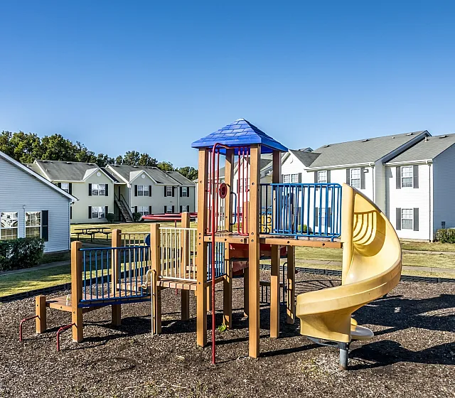 Children's playground with colorful slides at Meadows West Memphis Apartments in West Memphis, AR