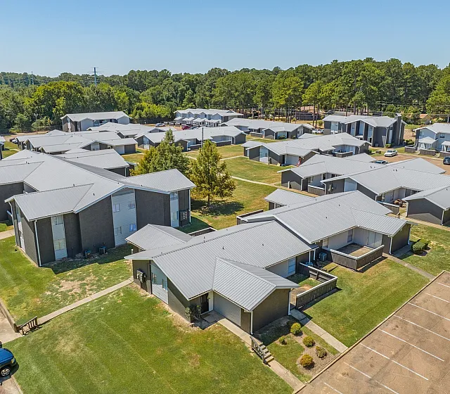 Low aerial view of townhome buildings and parking at Pines Apartments in Jackson, MS