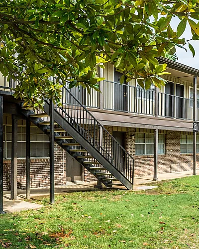 Exterior stairway under a shady tree at Windsor Place Apartments in Memphis, TN