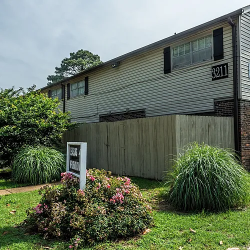 Landscaped grounds with shrubs and fenced patios at Windsor Place Apartments in Memphis, TN