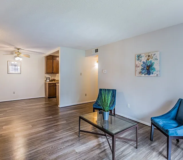 Bright living room with blue accent chairs at Hickory Pointe in Memphis, TN