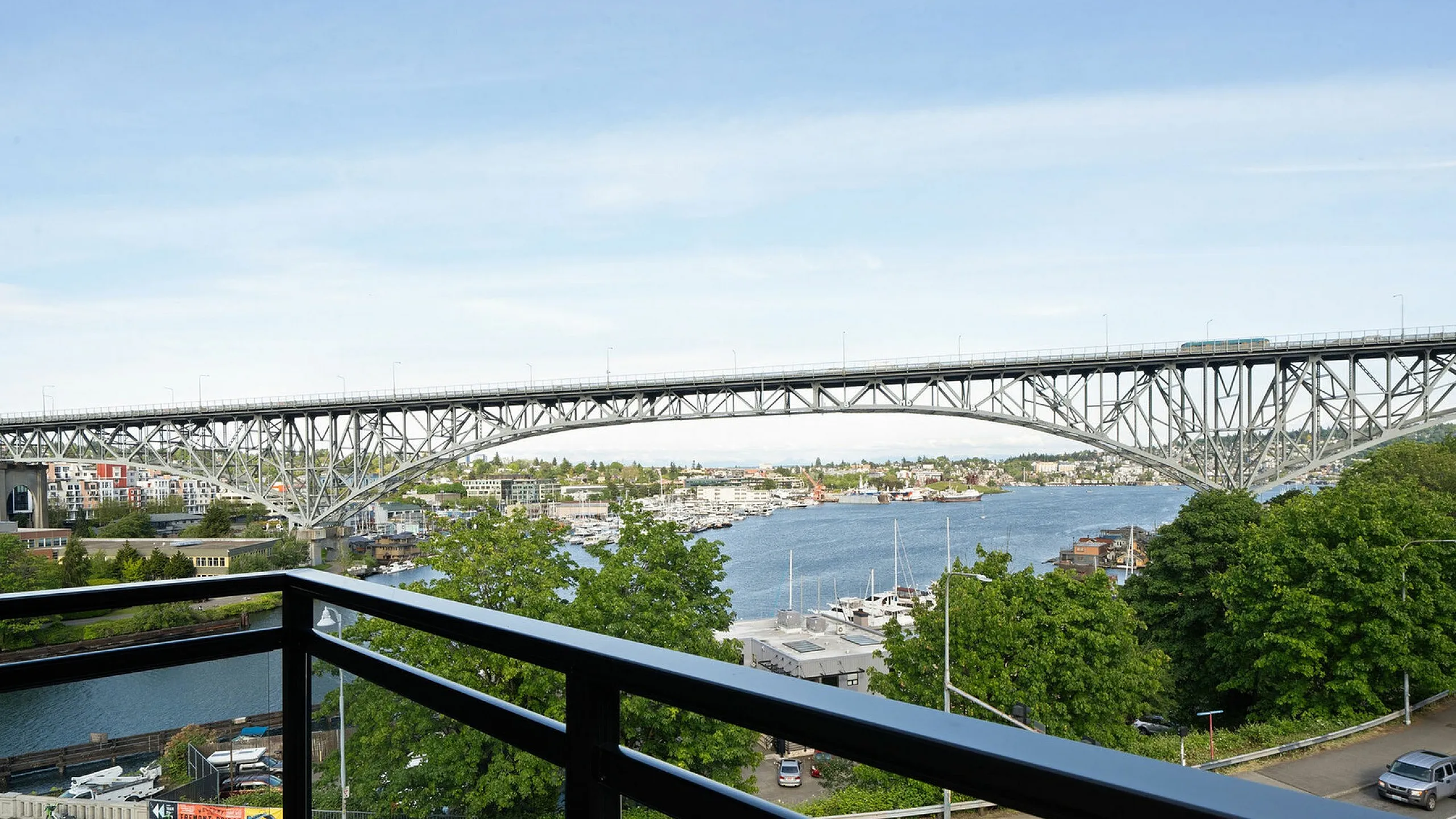 Spectacular riverside view from the apartment balcony overlooking a scenic bridge and bustling marina.