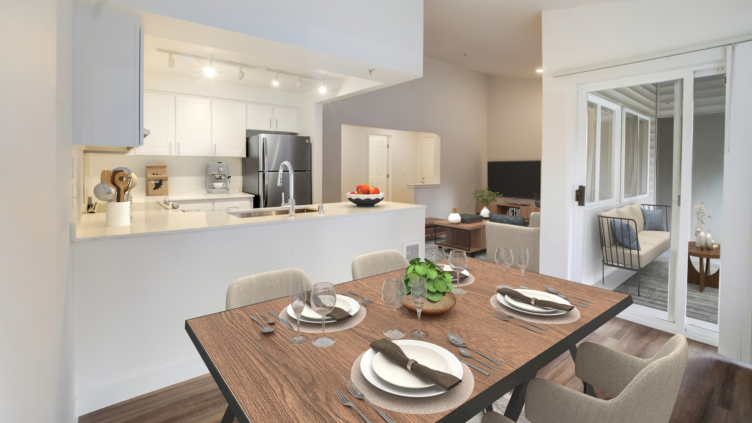 Inviting open-concept dining and kitchen area with elegant table setting, modern appliances, and a cozy living space leading to a bright sunroom.