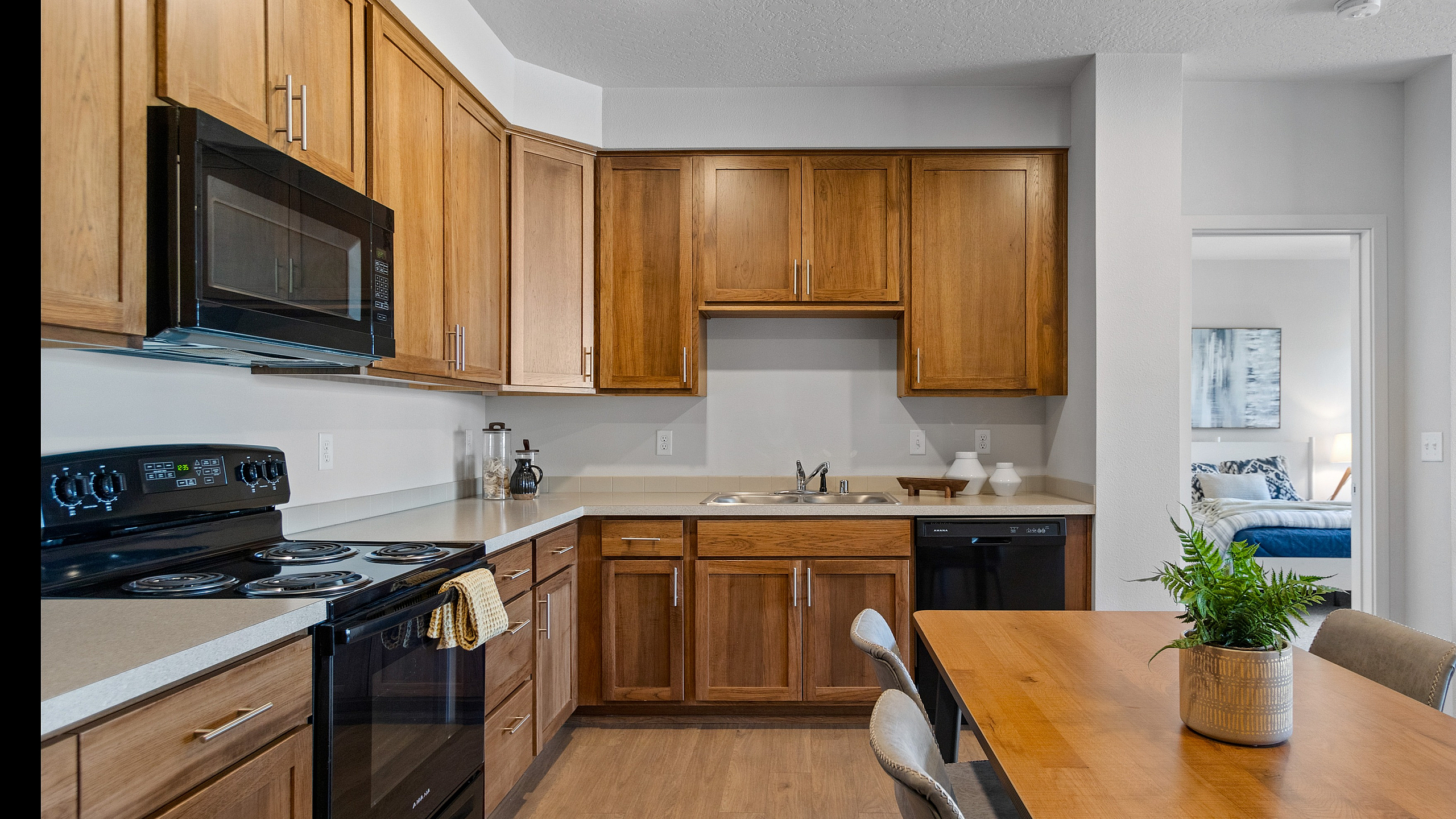 Modern kitchen with wooden cabinets, sleek appliances, and a cozy dining area.