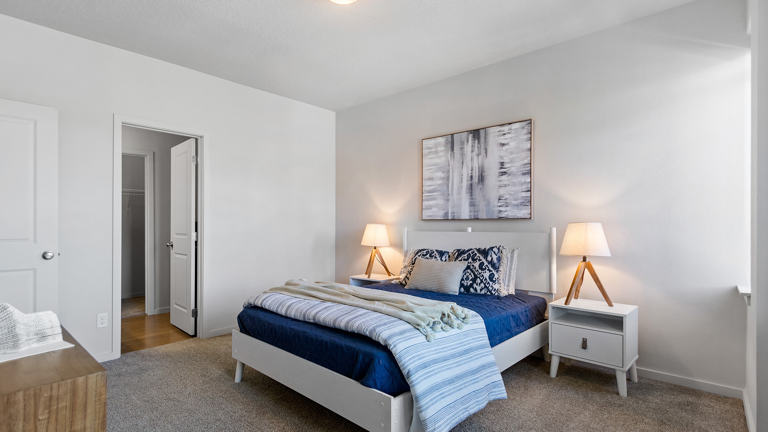 Inviting bedroom with modern decor featuring a comfortable bed, stylish lamps, and a serene color palette.