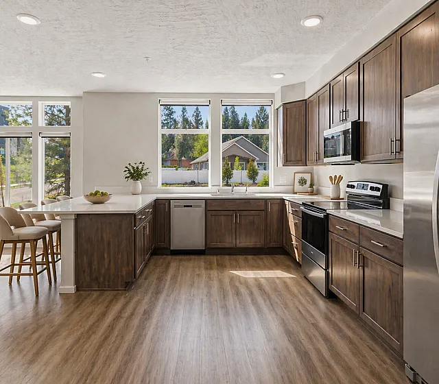 Bright and inviting modern kitchen with sleek stainless steel appliances, elegant wooden cabinetry, and large windows that flood the space with natural light.