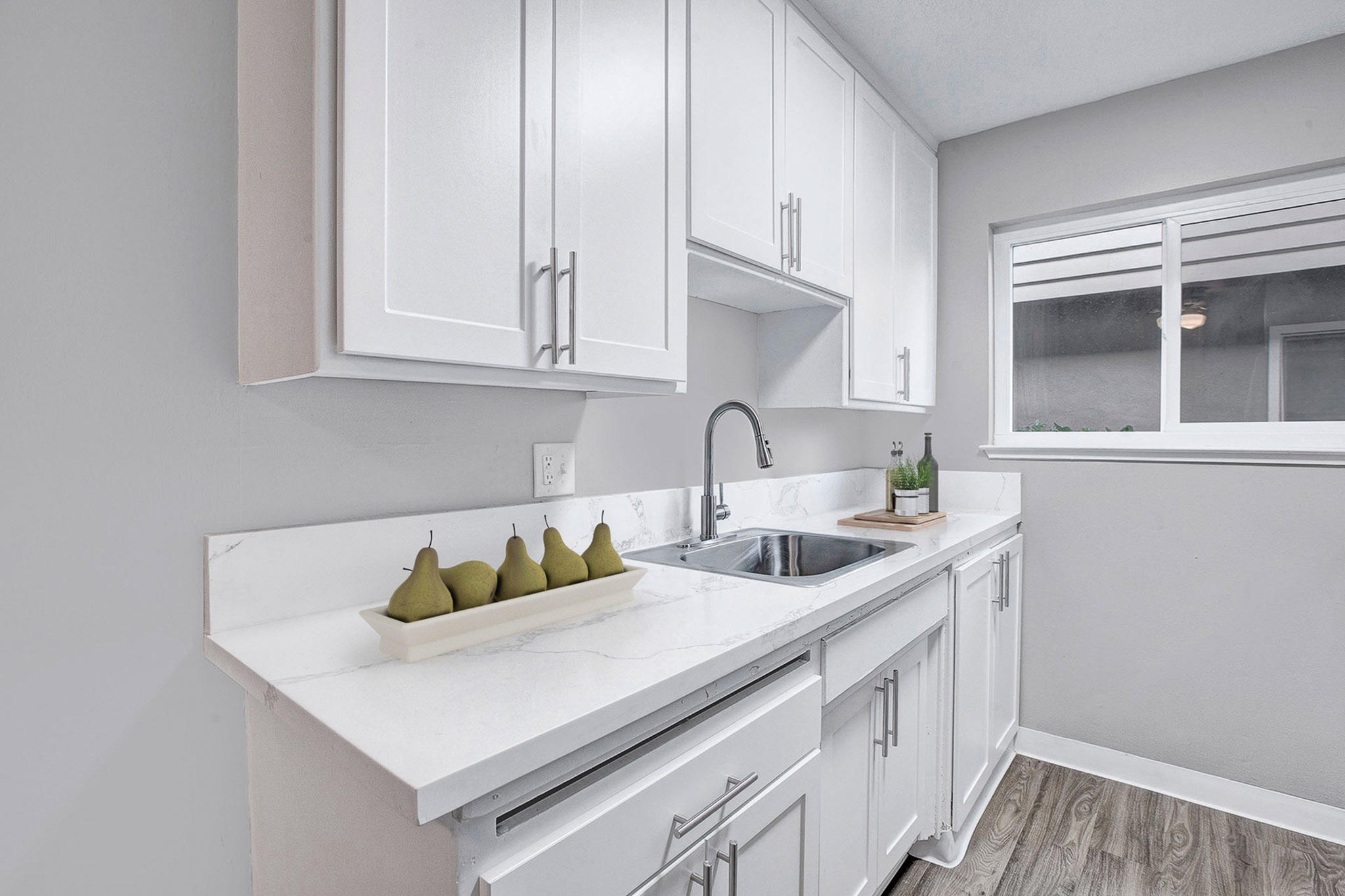 Renovated studio apartment kitchen with quartz countertops and dishwasher