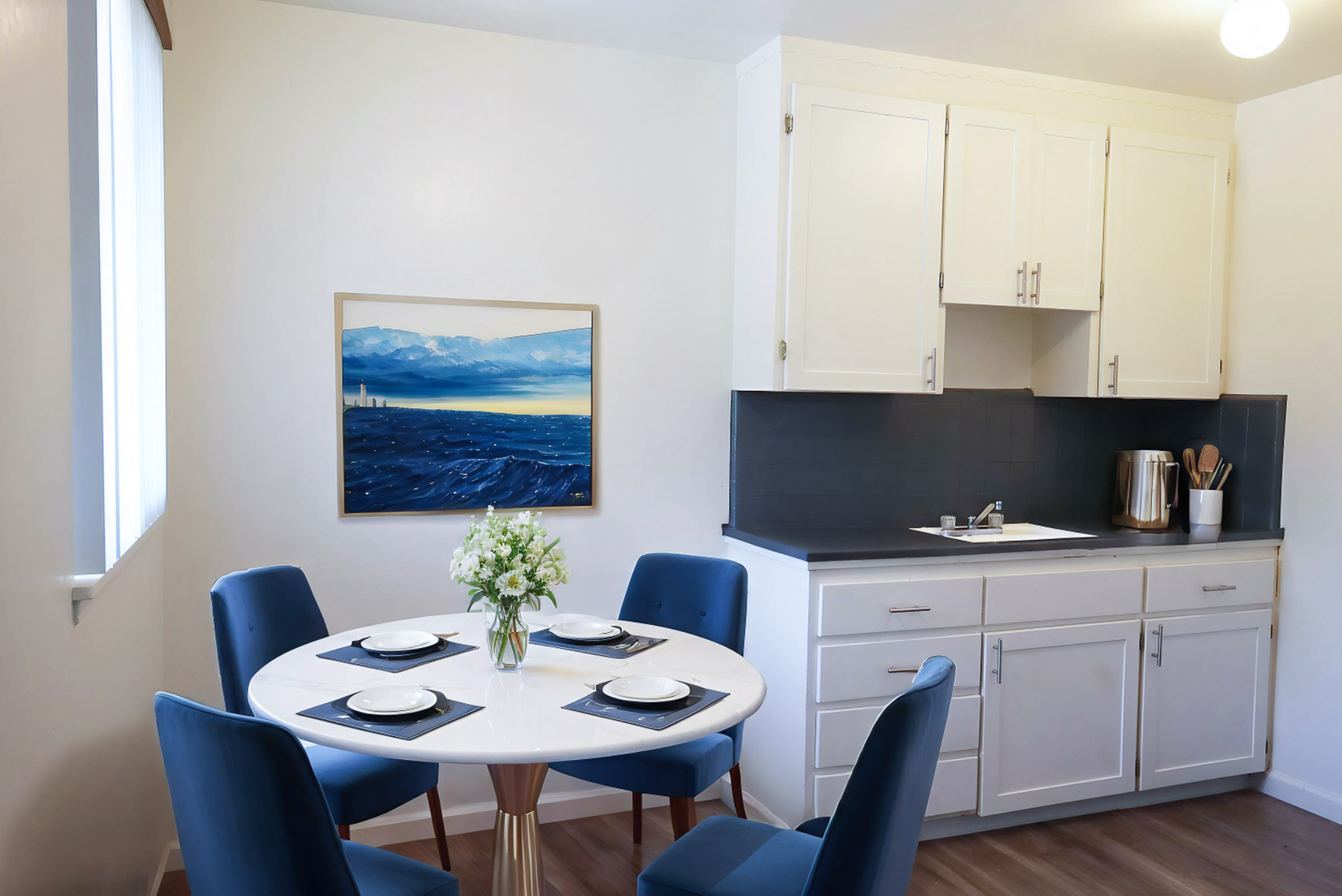 Dining area next to kitchen counter with white cabinetry