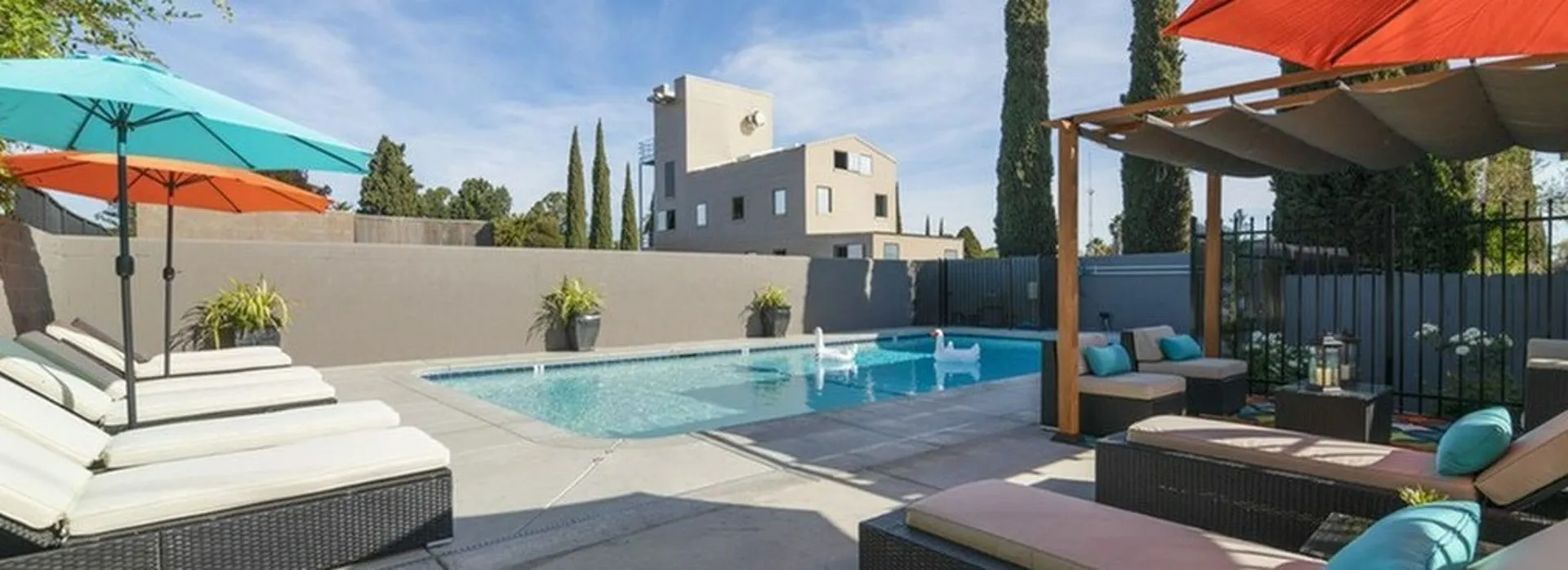Pool with lounge chairs and planters surrounding.