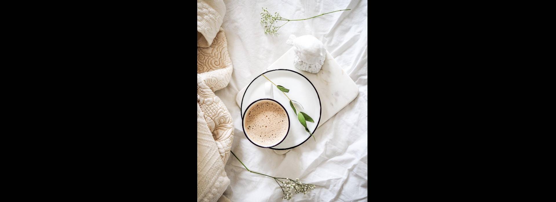 Cozy bedding with a cup of hot cocoa.