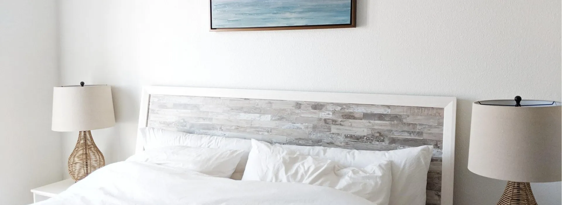 Bed with white comforter and bedside table