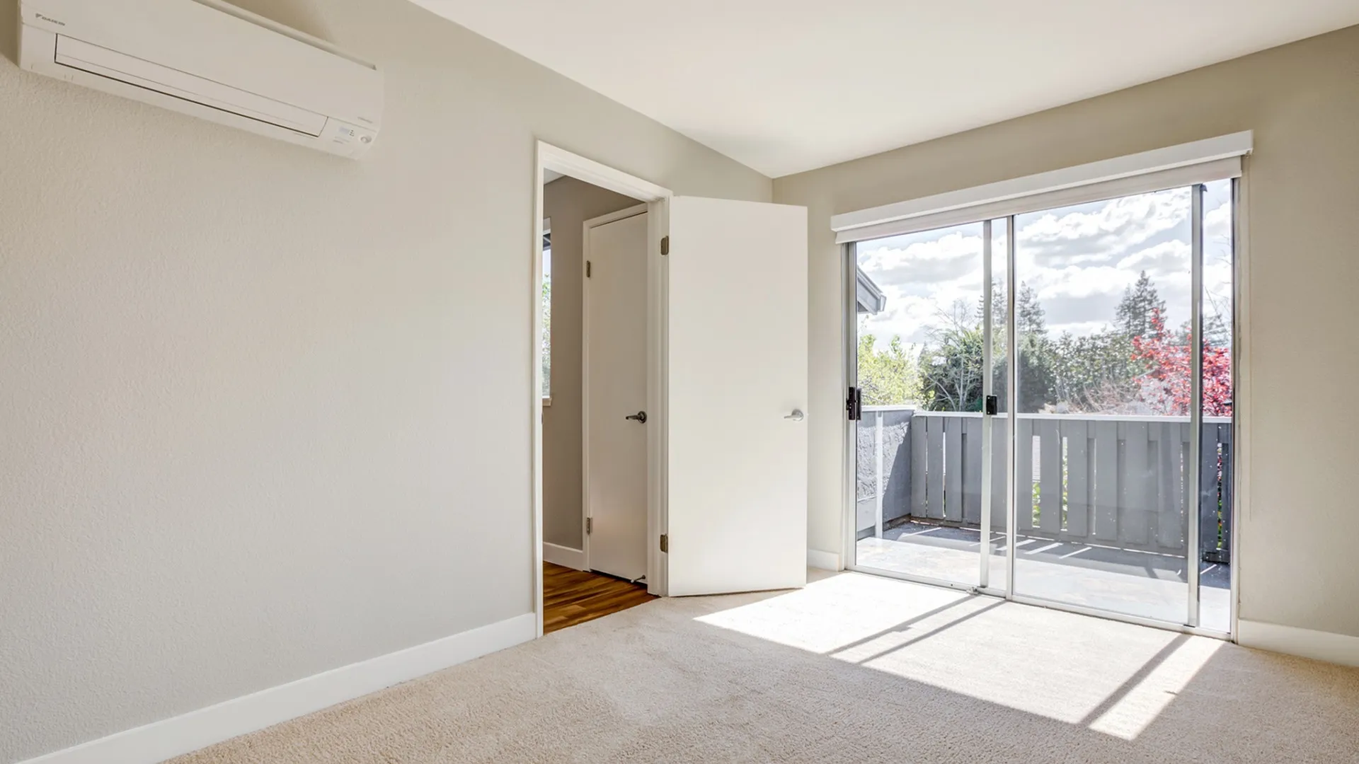 Bright bedroom with new carpet and balcony