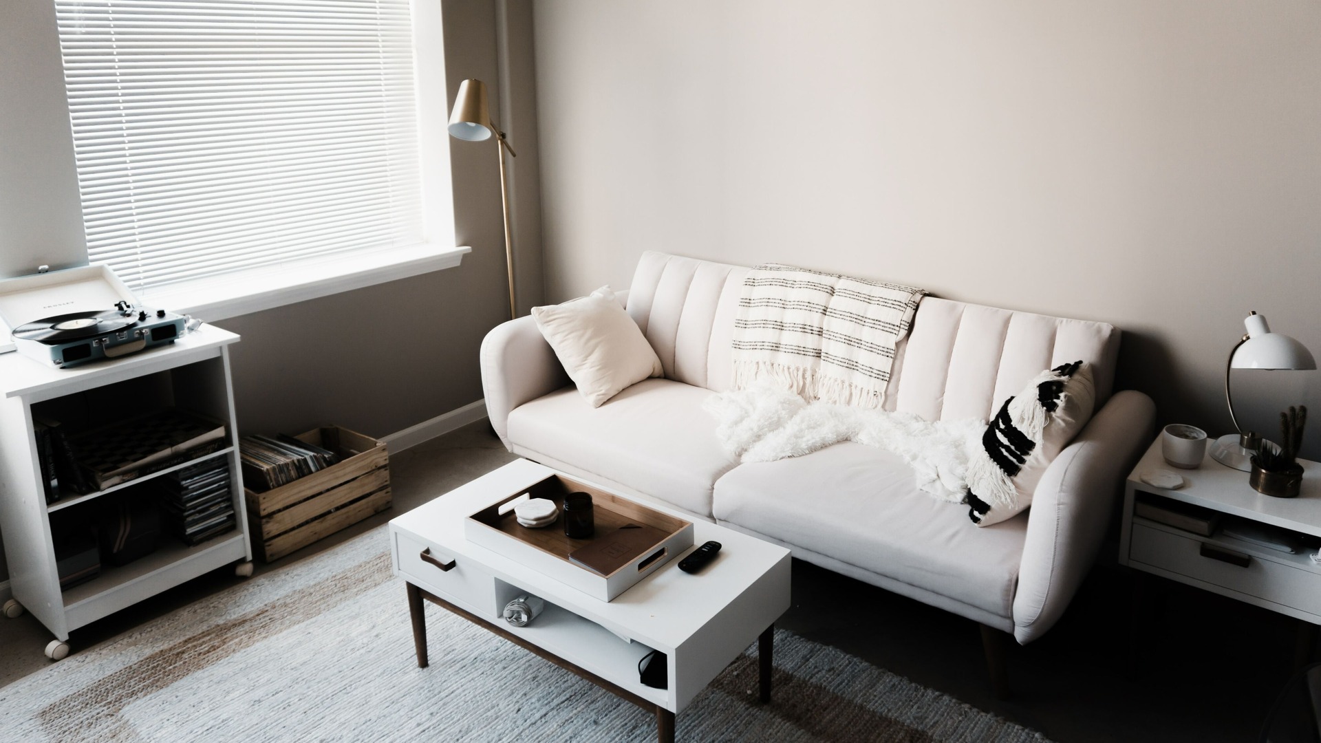 white couch, white coffee table, white end table with lamp