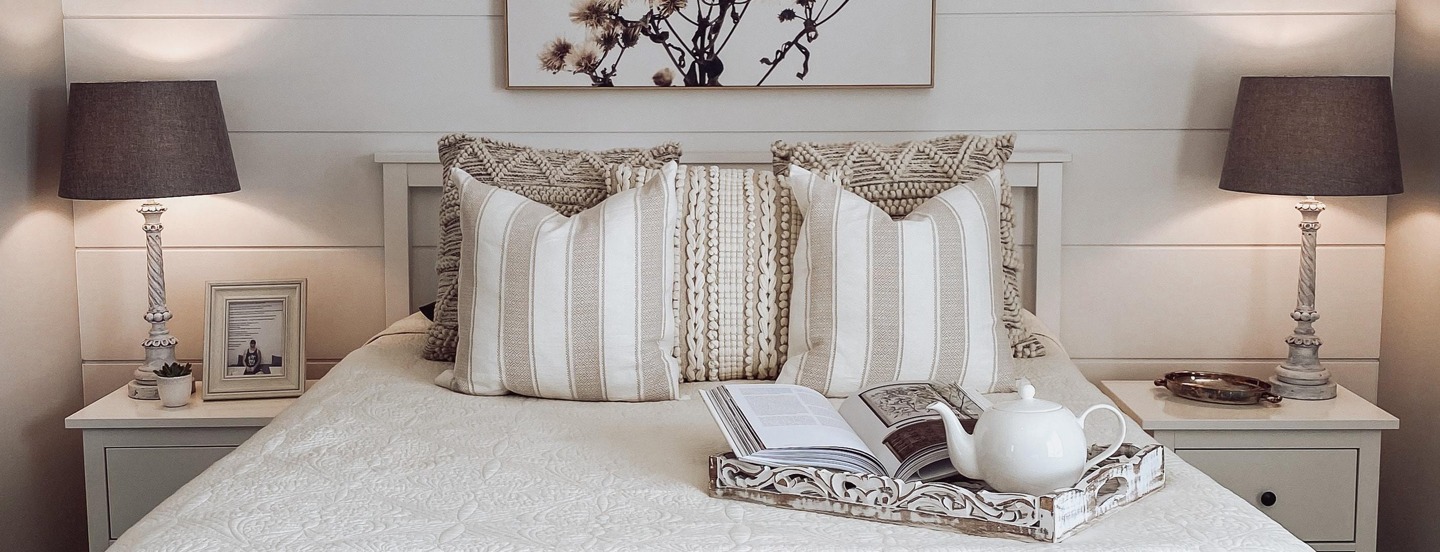 Comfy queen bed made up with large pillows, a tray with book and teapot waiting.