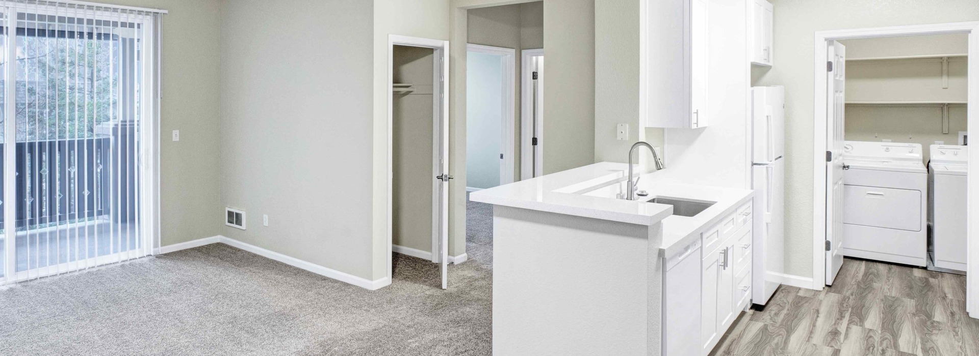 Apartment interior showing kitchen, living area, and laundry room