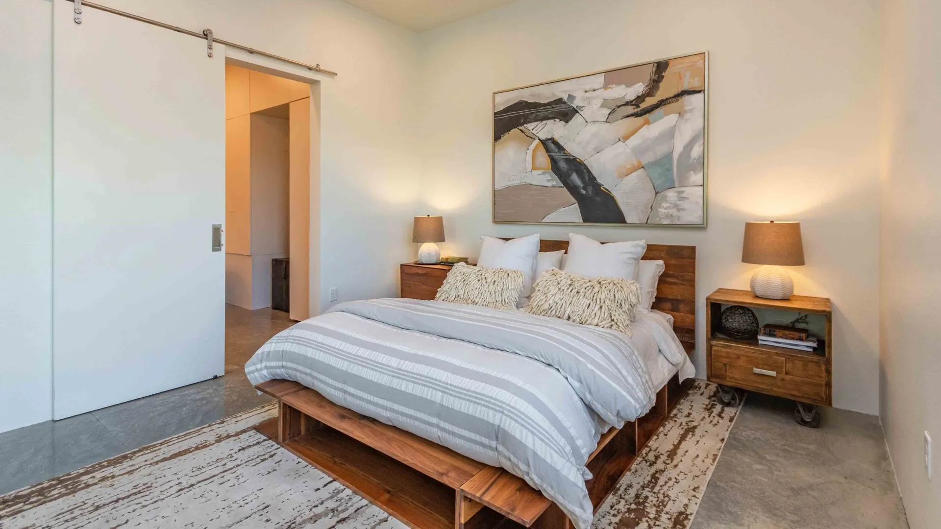 Bedroom with art above the bed and sliding barn door