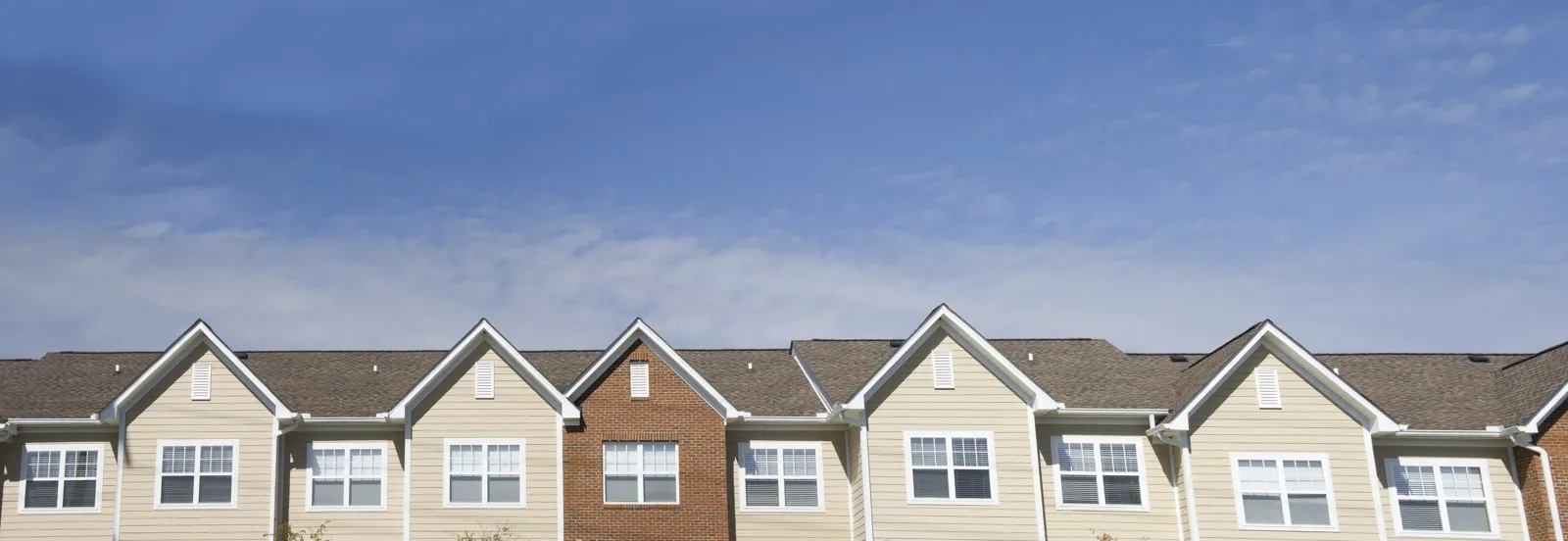 skyline of apartment building with clouds lining the roofs of the apartments.