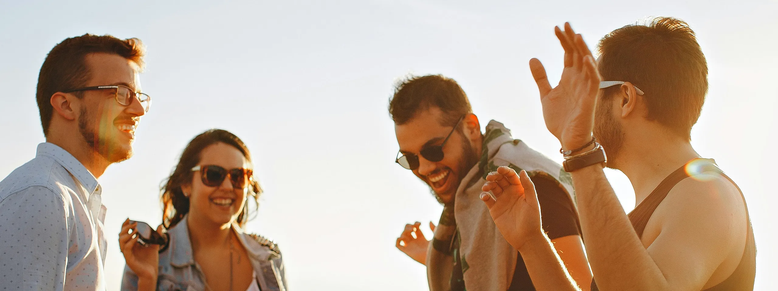 Group of smiling folks outside on a bright day