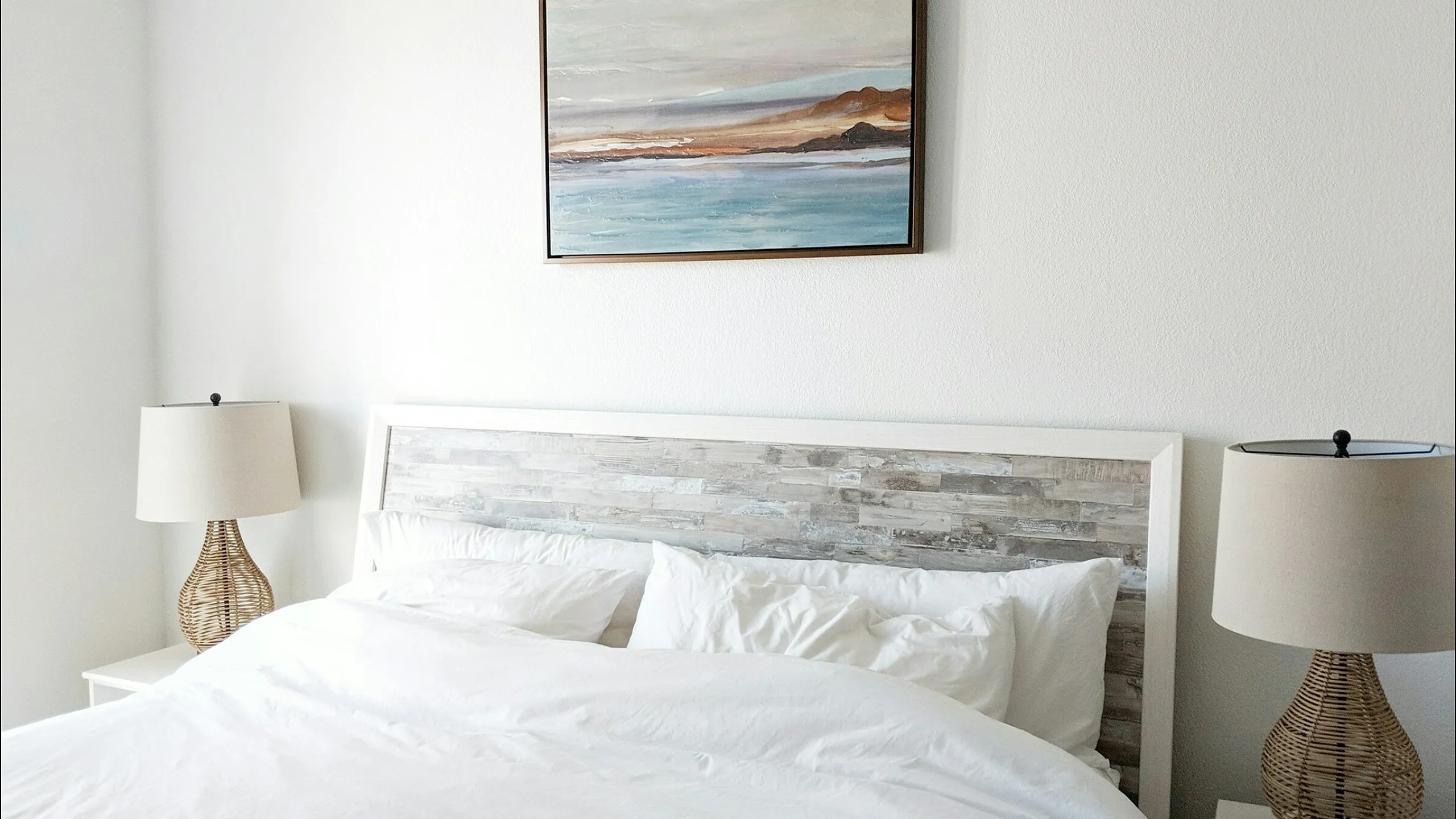 Peaceful bedroom with a pair of nightstands with lamps and wall art