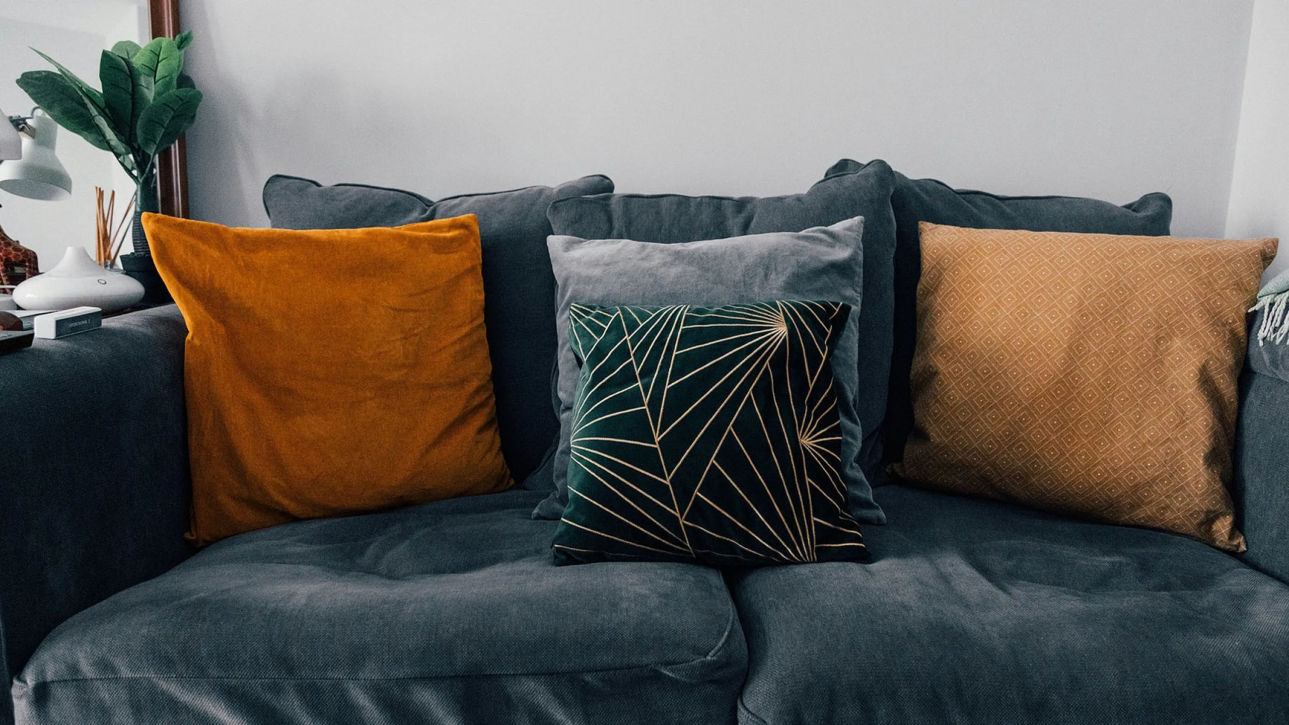 Grey plush couch with four throw pillows