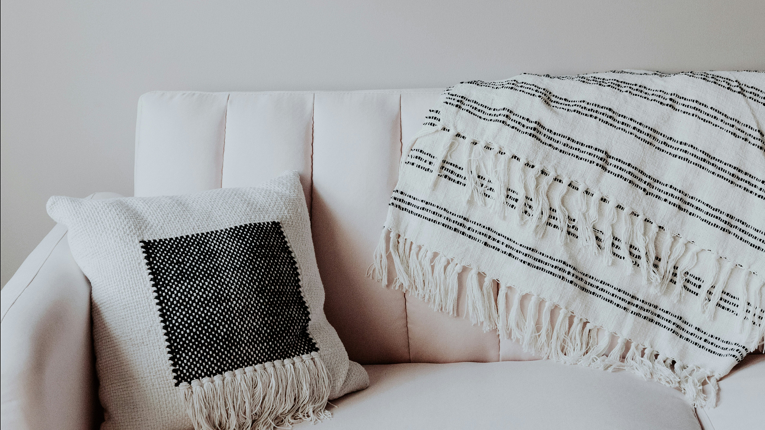 White couch with throw pillow and blanket
