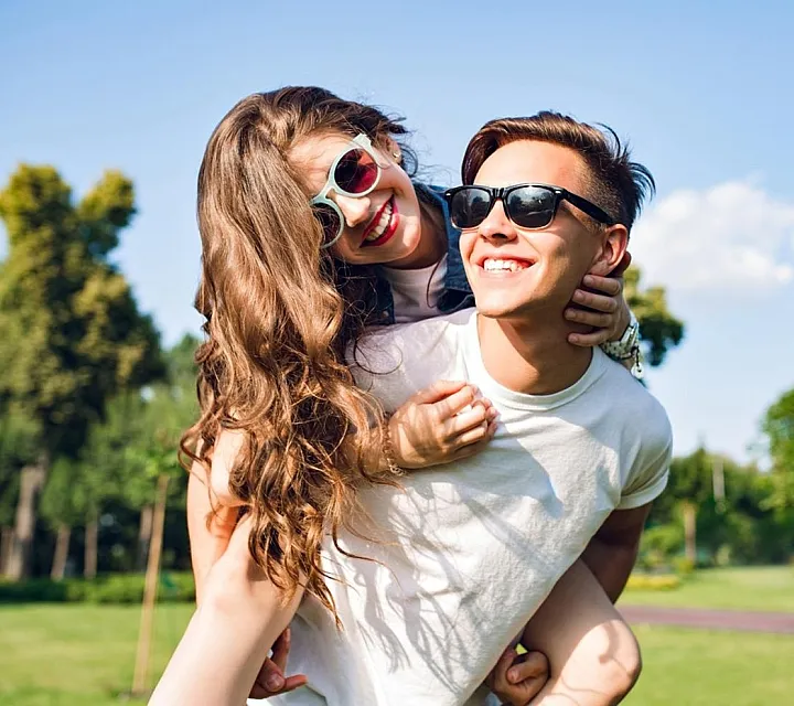 Photo of a couple at the park on a clear sky day.