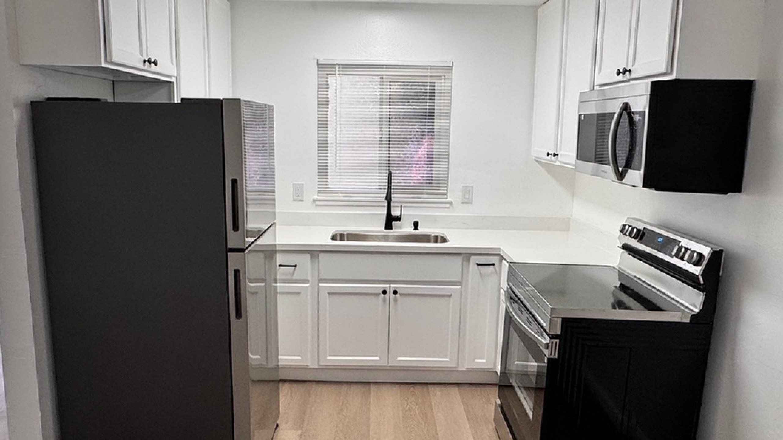 Remodeled Kitchen with White cabinets and Stainless Steel appliances