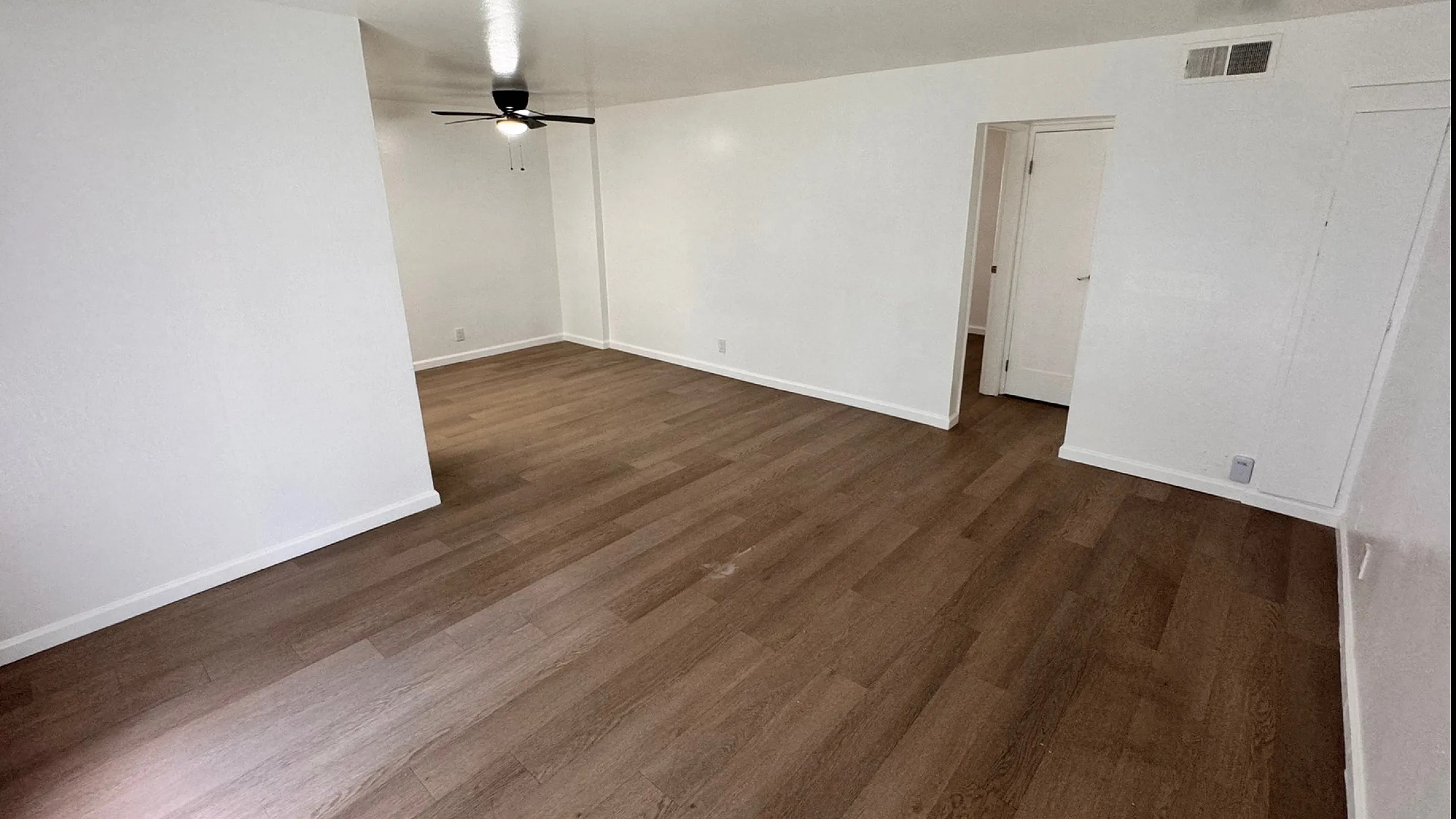 Bright open empty Living and Dining with woodstyle flooring,